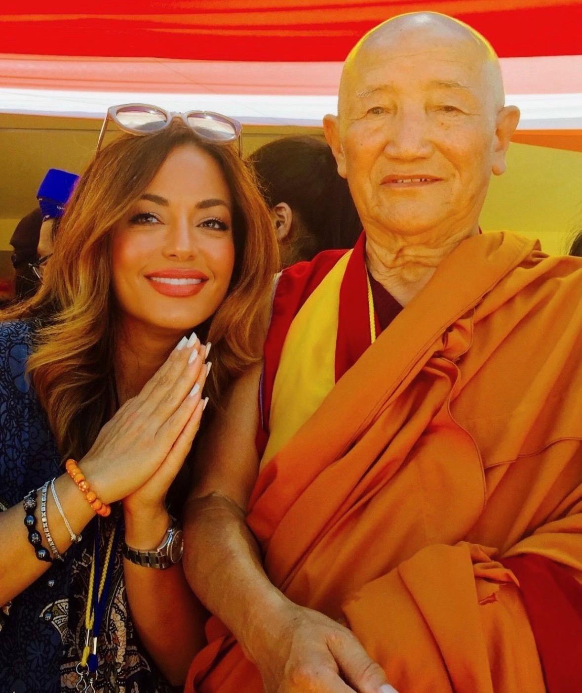 Dr. Nelly Zahiri greeting a Buddhist monk at a peace gathering